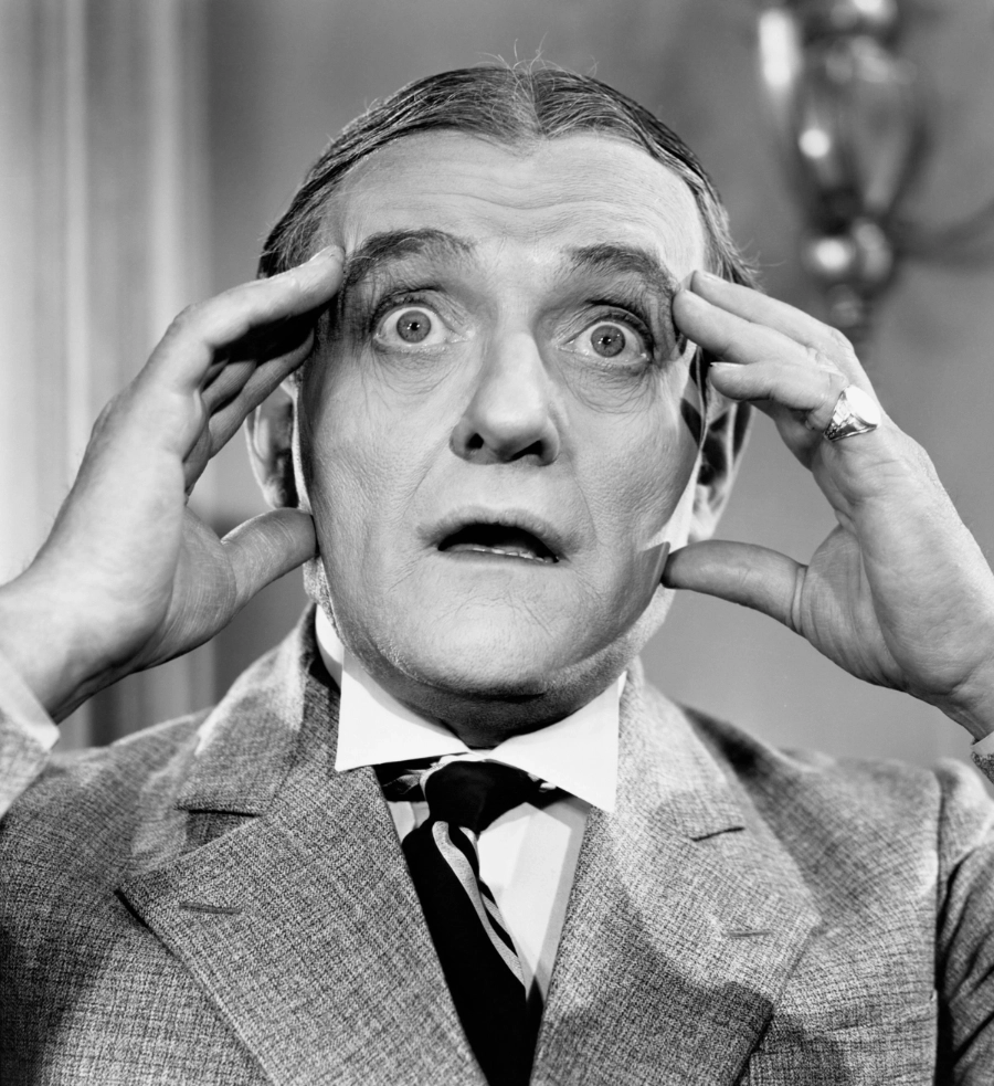 A man in shock and horror, holding the sides of his head.